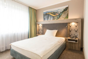 Queensize-Bett mit Bergefoto, Premium-Zimmer, Hotel Bavaria Oldenburg