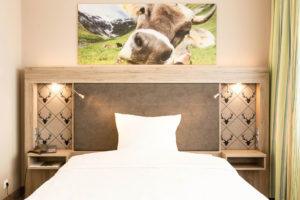 Bett mit Kuhfoto, Premium-Zimmer, Hotel Bavaria Oldenburg
