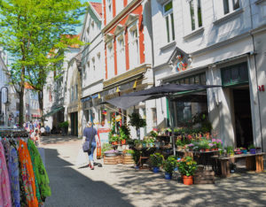 Fußgängerzone mit Blumen vor einem Geschäft
